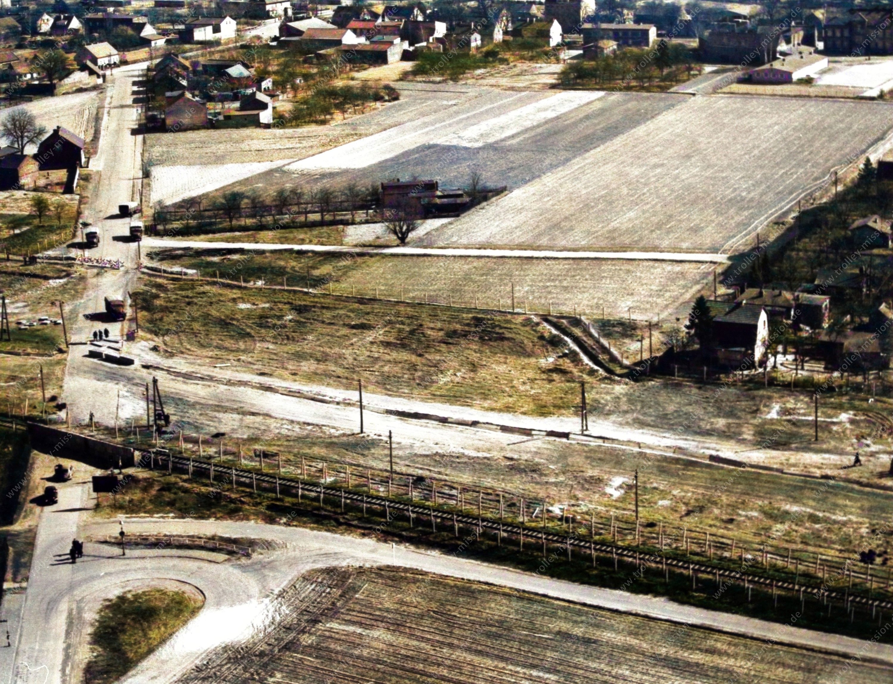 Das Luftbild zeigt einen Teil des Wilhelmsruher Damms in Berlin-Reinickendorf, wo die Grenze zwischen den Berliner Ortsteilen Wittenau und Rosenthal verläuft. Ganz links im Bild verläuft von oben nach unten der Wilhelmsruher Damm und wird diagonal verlaufend von der damaligen Sperrmauer und den Grenzzäunen unterbrochen.