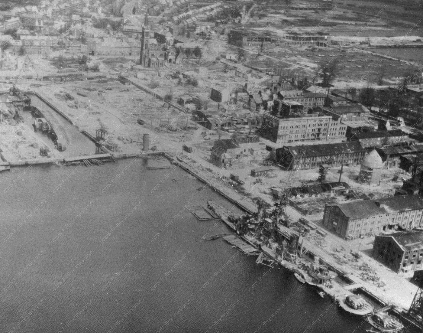 Die erste Luftaufnahme zeigt die Nordseite des Bauhafens und das Dock Nr. 6, in welchem ein zur Seite gekipptes Kriegsschiff versunken ist.