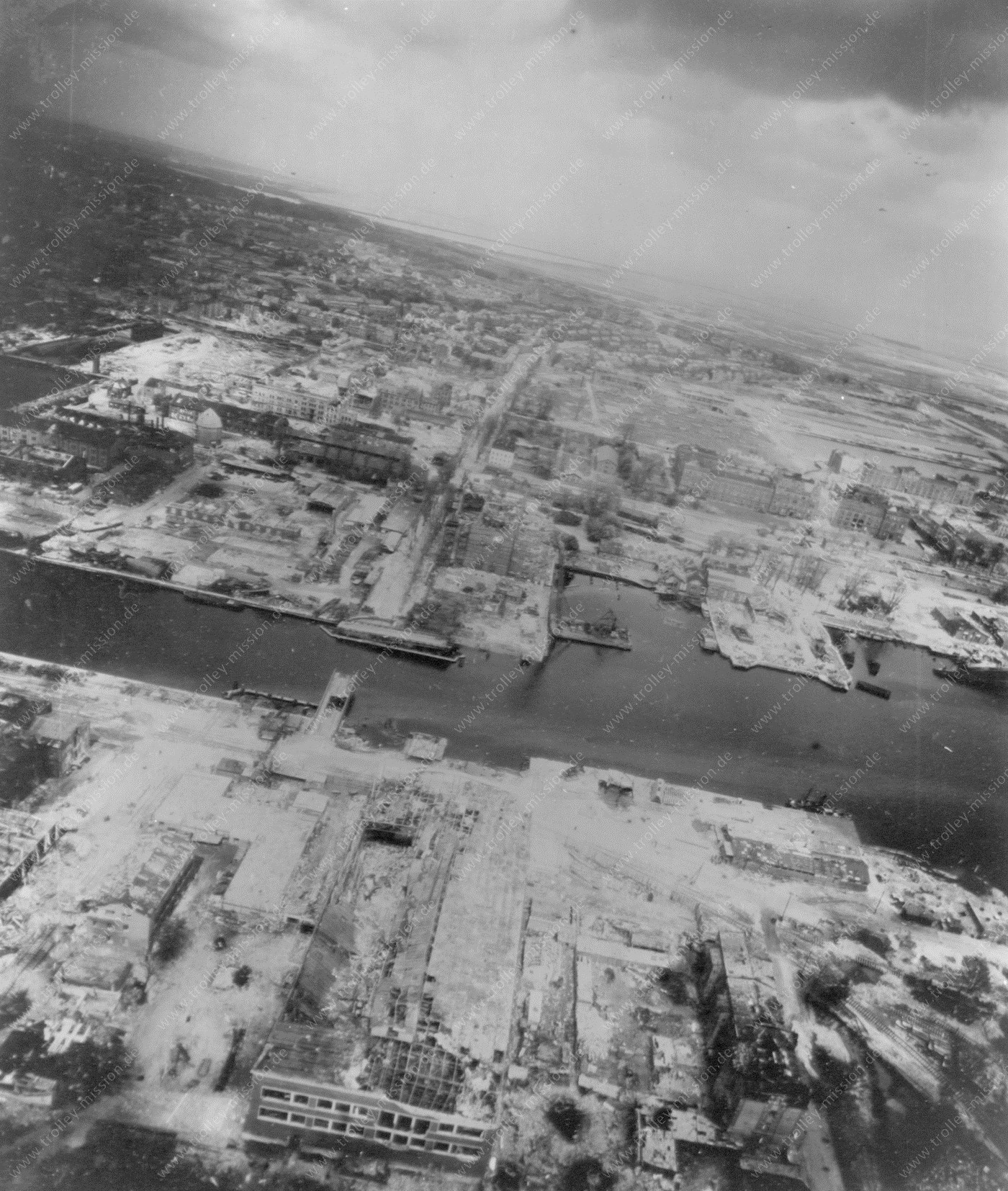 Die dritte Luftaufnahme zeigt den Ausrüstungshafen und die Ausrüstungswerft, wo seinerzeit der Torpedoschießstand angesiedelt war und der Hafenkanal verlief, der die Zufahrt zum Bauhafen ermöglichte.