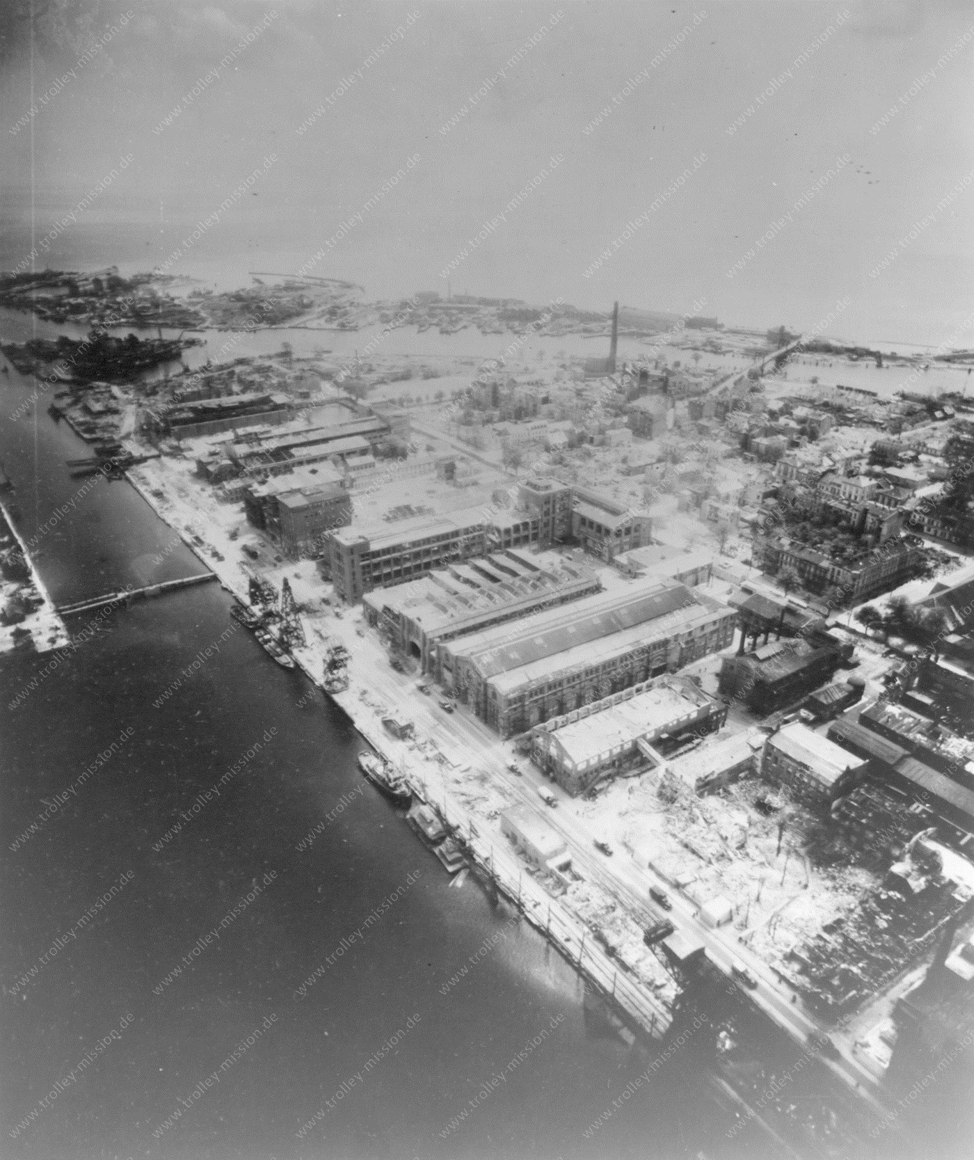 Die fünfte Luftaufnahme zeigt die südliche Kaimauer der Marinewerft im Bauhafen, wo damals zahlreiche Werkstätten angesiedelt waren.